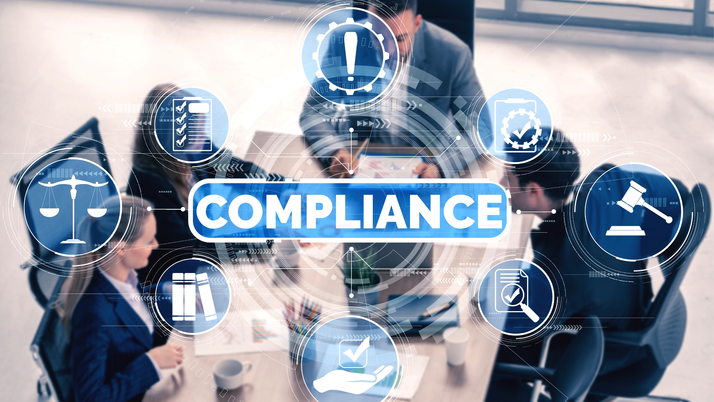 Overhead view of a business meeting with digital icons and the word ‘COMPLIANCE’ overlaid, symbolising coordinated risk and regulatory management.
